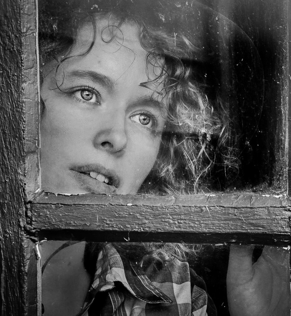 Avigail looking through an old window pane